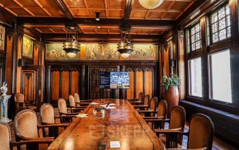Vergaderruimte in kantoorpand Nieuwezijds Voorburgwal 162, Amsterdam Centrum. Houten interieur met grote tafel, stoelen en een TV-scherm.