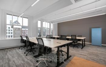 Ruime lichte kantoorruimte met meerdere bureaus en stoelen, gelegen in het kantoorpand op Rokin 92-96, Amsterdam Centrum. Geschikt voor professioneel gebruik met uitzicht op de stad.