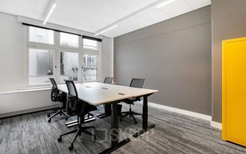 Vergaderruimte met een grote tafel en zes stoelen op kantoor Rokin 92-96, Amsterdam Centrum, ideaal voor kantoorruimte huren.