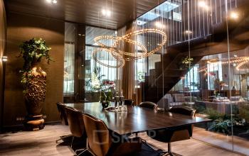 Moderne vergaderruimte in kantoorpand aan Muiderstraat 1, Amsterdam Centrum, met stijlvolle houten tafel en comfortabele stoelen, te huur voor zakelijke bijeenkomsten.