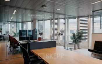 Moderne kantoorruimte huren in Amsterdam Centrum, gelegen op Muiderstraat 1. De ruimte heeft grote ramen, stijlvolle houten vloeren en een uitnodigend open vloerplan met moderne werkplekken. Ideaal voor zakelijke activiteiten.