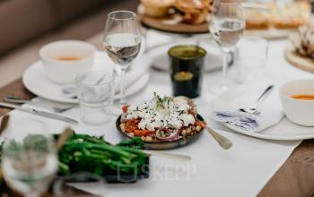 Gedeelde werkruimte in kantoor aan Muiderstraat 1, Amsterdam Centrum, met moderne meubels, vergadertafel, stoelen en glazen wanden. Personen zijn in gesprek en bezig met zakelijke activiteiten.