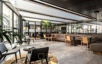 Modern kantoorpand aan Muiderstraat 1, Amsterdam Centrum, met ruime werkplekken, veel daglicht, en een uitnodigende zithoek. Ideaal voor ondernemers die kantoorruimte willen huren in een centrale omgeving.