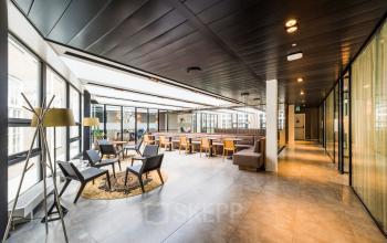 Kantoorruimte huren op Muiderstraat 1, Amsterdam Centrum met moderne en lichte open indeling, ingericht met stijlvolle stoelen en tafels, geschikt voor diverse zakelijke activiteiten.