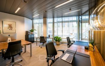 Stijlvolle kantoorruimte in Amsterdam Centrum op Muiderstraat 1 met moderne werkplekken, grote ramen en groene accenten. Ideaal voor wie kantoorruimte wil huren midden in de stad.