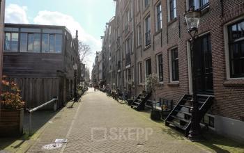 Straatbeeld op Prinseneiland 23A, Amsterdam Centrum met traditionele bakstenen gebouwen en fietsen geparkeerd langs de trottoir. Ideale locatie om kantoorruimte te huren.