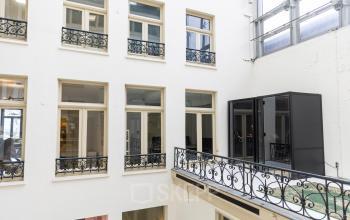 Kantoor aan Prins Hendrikkade 21, Amsterdam Centrum, met een modern atrium en glazen gevels. Ideaal voor wie kantoorruimte wil huren in een inspirerende omgeving.