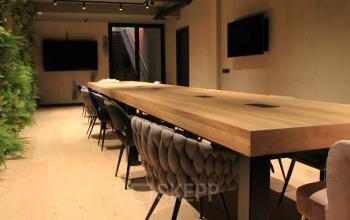 Stijlvolle gemeubileerde vergaderruimte in kantoorpand Hekelveld 8-10, Amsterdam Centrum. Houten tafel, comfortabele stoelen en moderne voorzieningen, ideaal voor zakelijke bijeenkomsten. Zoek je kantoorruimte huren met karakter? Dit is het perfecte