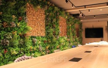 Kantoorruimte huren in Amsterdam Centrum bij Hekelveld 8-10 met een moderne lange tafel en groene plantenwand, ideaal voor samenwerken en vergaderingen.