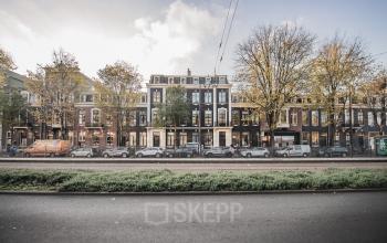 Exterieur van het kantoorpand op Westeinde 14-16, Amsterdam Centrum met geparkeerde auto's en bomen langs de straat.