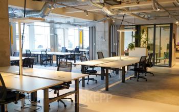 Moderne kantoorruimte op Weesperplein 4b in Amsterdam Centrum, voorzien van ruime werkplekken met ergonomische bureaustoelen en veel daglicht. Ideaal voor kantoorruimte huren met focus op samenwerking.