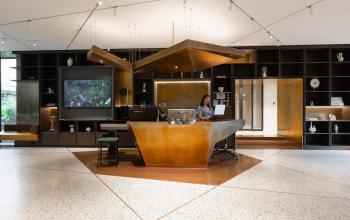 Moderne kantoorruimte huren aan de Herengracht 471 in Amsterdam Centrum met stijlvolle receptie, een receptioniste achter de balie op de werkplek.