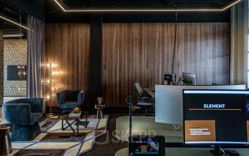 Kantoorruimte huren aan Stationsplein 9, Amsterdam Centrum met moderne inrichting, werkplekken en zithoek