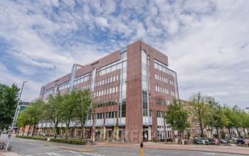 Straathoek van kantoorpand op Weesperstraat 107-121 in Amsterdam Centrum met meerdere verdiepingen en bakstenen gevel. Deze locatie biedt een ideale mogelijkheid om kantoorruimte te huren in een levendige omgeving.