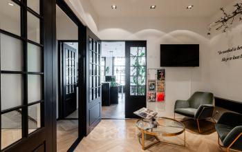 Stijlvolle wachtruimte in het kantoorpand op Rokin 46-1 in Amsterdam Centrum, met comfortabele stoelen, een moderne salontafel en tijdschriften, klaar voor kantoorruimte huren.