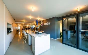 Moderne kantoorruimte aan de Groenmarktkade 5-H in Amsterdam Centrum met werkplekken, vergaderruimte en keuken, klaar voor huur. De ruimte is licht en professioneel ingericht, ideaal voor zakelijke activiteiten.