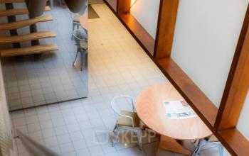 Moderne kantoorruimte huren aan de Kerkstraat 204 in Amsterdam, met hoge plafonds, houten elementen en een centrale tafel met stoelen. Rustige omgeving voor zakelijke bijeenkomsten.