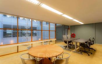 Ruime kantoorruimte op Kerkstraat 204, Amsterdam Centrum met grote ramen en moderne meubels. Ideaal voor kantoorruimte huren met diverse bureaus en vergadertafels.