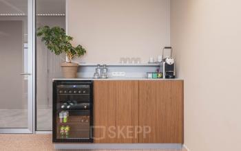 Moderne pantry in een kantoorpand op Piet Heinkade 55, Amsterdam Centrum, voor kantoorruimte huren. Uitgerust met een koelkast, koffiezetapparaat en glazen, klaar voor gebruik.