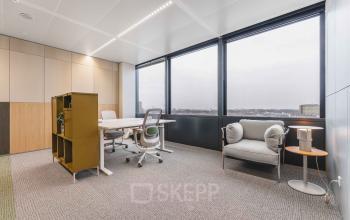 Moderne kantoorruimte te huur aan de Piet Heinkade 55, Amsterdam Centrum, met grote ramen en stijlvolle meubels, ideaal voor huurders die een lichte en luchtige werkplek zoeken.