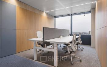 Moderne kantoorkamer met houten panelen, witte bureaus en ergonomische stoelen, ideaal voor kantoorruimte huren aan Piet Heinkade 55 in Amsterdam Centrum.