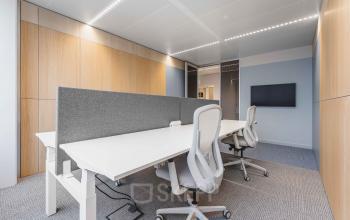 Moderne kantoorruimte met houten panelen op Piet Heinkade 55, Amsterdam Centrum, geschikt voor het huren van een kantoorpand. Meubilair bestaat uit witte bureaus en comfortabele stoelen.