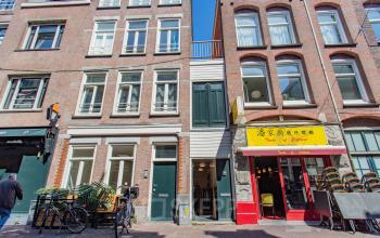 Kantoorpand gelegen aan de Korte Leidsedwarsstraat 133A in Amsterdam Centrum, met een karakteristieke gevel en diverse winkels aan de straatkant. Voorkant met fietsen en uitstalling.