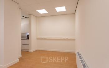 Lege kantoorruimte met houten vloer en witte muren op Korte Leidsedwarsstraat 133A 133A, Amsterdam Centrum. Geschikt voor kantoorruimte huren met lichte kleuren en strakke afwerking.