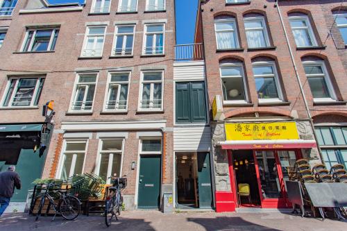 Kantoorpand gelegen aan de Korte Leidsedwarsstraat 133A in Amsterdam Centrum, met een karakteristieke gevel en diverse winkels aan de straatkant. Voorkant met fietsen en uitstalling.