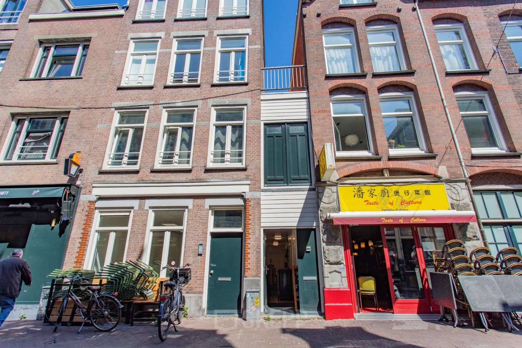 Kantoorpand gelegen aan de Korte Leidsedwarsstraat 133A in Amsterdam Centrum, met een karakteristieke gevel en diverse winkels aan de straatkant. Voorkant met fietsen en uitstalling.