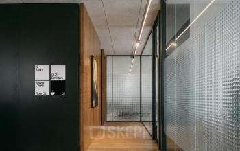 Moderne kantoorruimte aan de Weteringschans 126 met houten vloeren, glazen wanden en strakke verlichting voor een professionele sfeer. Ideale locatie voor kantoorruimte huren in Amsterdam Centrum.