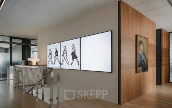Stijlvolle kantoorruimte op Weteringschans 126, Amsterdam Centrum, met moderne kunst aan de muur en glaspartities.