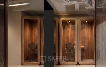 Moderne kantoorruimte op Weteringschans 26 in Amsterdam Centrum met strakke design elementen en telefoonhokjes, ideaal voor verhuur.