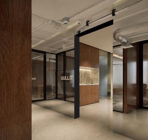 Moderne kantoorruimte in Amsterdam Centrum met glazen wanden en houten accenten, ideaal voor huur. De ruimte straalt een stijlvolle en professionele sfeer uit.