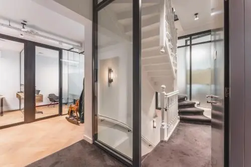 Entree van een modern kantoorpand met glazen wanden en een stijlvolle trap op Hekelveld 8-10, ideaal voor kantoorruimte huren in Amsterdam Centrum.