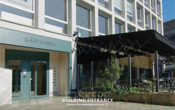 Ingang van het kantoorpand op Kleine Gartmanplantsoen 21 in Amsterdam Centrum, met een uitnodigende gevel en glazen deuren. Ideaal voor kantoorruimte huren in het hart van de stad.