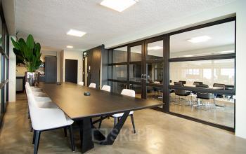 Moderne vergaderruimte in het kantoorpand op Kleine Gartmanplantsoen 21, Amsterdam Centrum, met grote tafel, stoelen en glazen wanden.