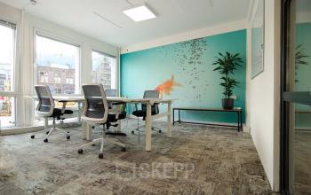 Kantoorruimte huren aan Kleine Gartmanplantsoen 21, Amsterdam Centrum met grote ramen, vergadertafel, stoelen en wanddecoratie.