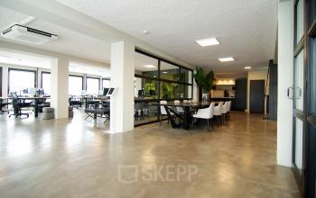 Moderne kantoorruimte huren op Kleine Gartmanplantsoen 21 in Amsterdam Centrum, met ruime werkplekken en vergadertafels in een open indeling.