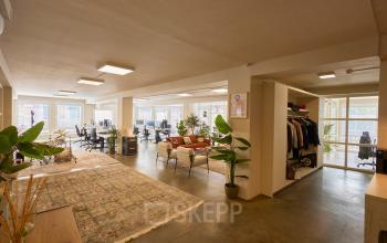 Open en lichte kantoorruimte in Amsterdam Centrum met werkplekken, planten en een ontspannen zithoek. Moderne en aantrekkelijke omgeving voor kantoorruimte huren.