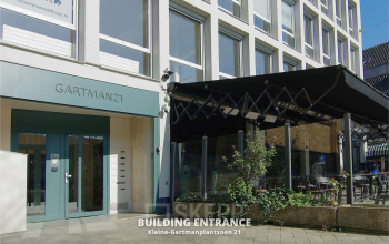 Vooraanzicht van een kantoorpand op Kleine Gartmanplantsoen 21 in Amsterdam Centrum, met moderne entree en terras. Ideaal om kantoorruimte te huren in het hart van de stad.