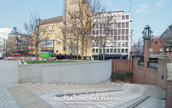 Entree naar een ondergrondse fietsenstalling op Kleine Gartmanplantsoen 21, in Amsterdam Centrum. Geschikt voor bezoek aan nabijgelegen kantoren en zakelijke locaties. Ideaal voor kantoorruimte huren in deze levendige omgeving.