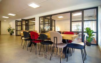 Moderne kantoorruimte huren in Amsterdam Centrum, Kleine Gartmanplantsoen 21. Heldere werkruimte met glazen wanden en kleurrijke stoelen, ideaal voor dynamische teams. Ruimte biedt volop mogelijkheden voor creativiteit en efficiëntie.