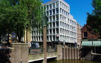 Exterieur van het kantoorpand aan Kleine Gartmanplantsoen 21, Amsterdam Centrum, met moderne gevel en grachtenzicht.