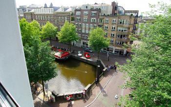 Uitzicht vanuit kantoorpand op Kleine Gartmanplantsoen 21, Amsterdam Centrum, met zicht op gracht en stadsleven.