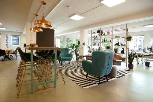 Gezellig open kantoor op Kleine Gartmanplantsoen 21, Amsterdam met comfortabele zitplekken en groene accenten. Ideale kantoorruimte huren voor creatieve professionals.