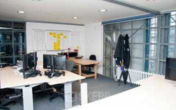 Kantoorruimte op Zuiderkerkhof 72, Amsterdam Centrum met meerdere bureaus, computerschermen en een whiteboard voor brainstormsessies. Ideaal voor bedrijven die een dynamische werkplek willen huren met veel interactiemogelijkheden.