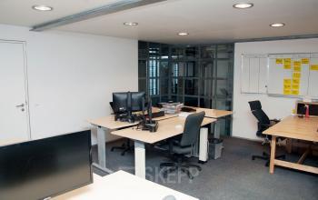 Moderne kantoorruimte in Amsterdam Centrum, Zuiderkerkhof 72 met bureaus, computerschermen en glazen wanden. Ideaal voor professioneel huren.