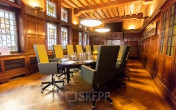 Stijlvolle vergaderruimte in een kantoorpand aan de Nieuwezijds Voorburgwal 104-108 in Amsterdam Centrum. Het interieur is ingericht met een lange tafel en comfortabele stoelen, ideaal voor kantoorruimte huren.