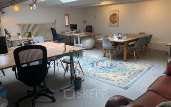 Moderne kantoorruimte te huur op Oudebrugsteeg 9 in Amsterdam Centrum met een mix van vintage en eigentijdse meubels en veel natuurlijk licht.